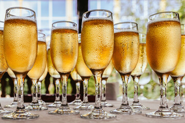 Glasses for champagne stand on the table in front of the buffet