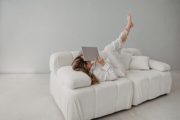 Top view of woman lying on sofa with book