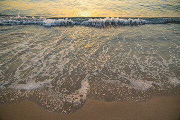 foam from the waves of sea water on a sandy beach