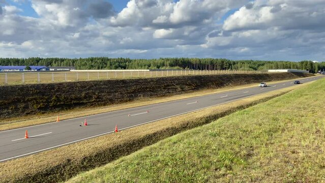Drag racing, racing cars compete in 402 meters. Arrivals of cars on a straight asphalt race track. Race cars during races. Sports car for a race on the track. Electric car competes in drag racing.