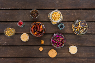 Top view image of kitchen spices and seasonings in glass jars on wooden boards