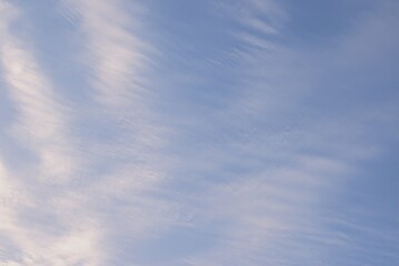 Blue sky on which white clouds and wind painted a picture in the style of abstractionasm