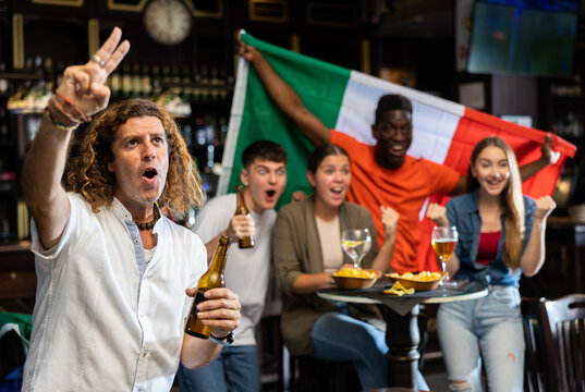 Joyful fans of the Italian team celebrating the victory in the night bar