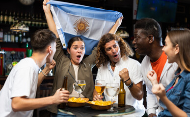 Joyful fans of the Argentina team celebrating the victory in the night bar