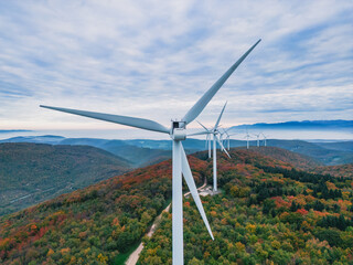 Close-up on the propellers of a wind turbine during a misty morning and sunrise. Green energy. Wind...