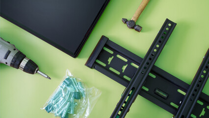 Wall mounting kit for TV or monitor. Bracket, screwdriver, fasteners, hammer and monitor screen on...