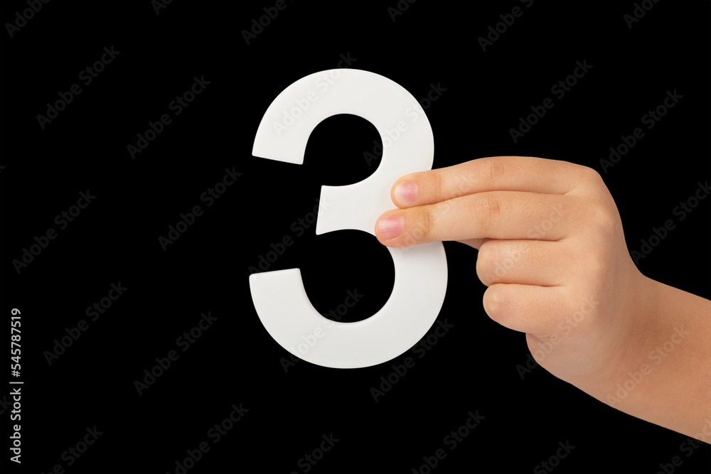 Poster number three in hand isolated on black background. number three in a child's hand on a black backgro