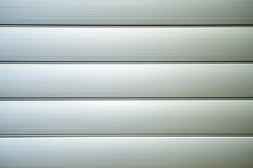 Obraz premium Background of a clean gray garage door, close-up. Shutters of closed blinds, copy space texture