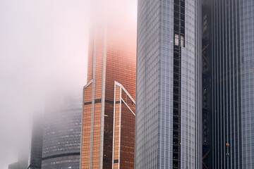 Windows of skyscrapers in the fog, background copy space. Metal structures with windows of a...