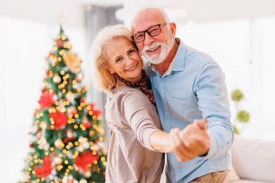 Senior couple hugging and dancing while celebrating Christmas at home