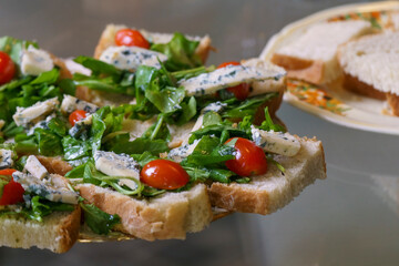 Fototapeta na wymiar High angle view of plate with brusquettes of bread, roquefort cheese, arugula and cherrys