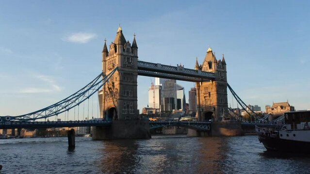 Tower Bridge London with Thames river and floating boat from the right. 