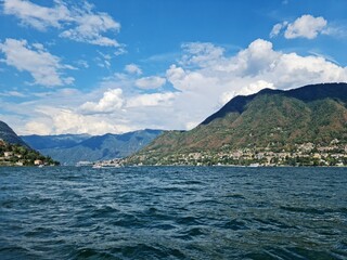 Lake Como country on a summer sunny day. View of the bay. Lake Como and mountains. Scenic view of the resort town. Beautiful Italian landscape.