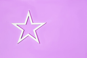 A white star on purple background. Minimal concept for Christmas or New Year 2023 card or banner. Flat lay. Copy space. Design for advertisement