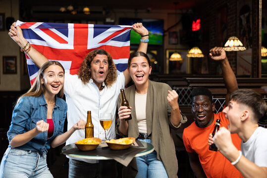 International group of people with UK flag toasting with beer, having fun at party in nightclub