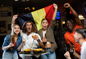 Happy fans celebrating the victory of Belgian team in the bar