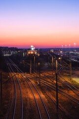 Fototapeta na wymiar Railway station in the evening scenery. Railroad tracks at Kielce Herby station, Poland.