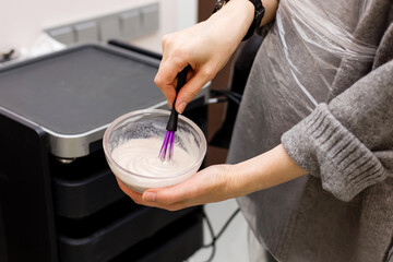 paint with a brush in the hands of a hairdresser