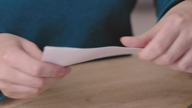 close-up female hands pull out paper envelope utility bill paper letter bank documents. caucasian woman hands opening paper letter post invoice tax forms. tear paper envelope concept