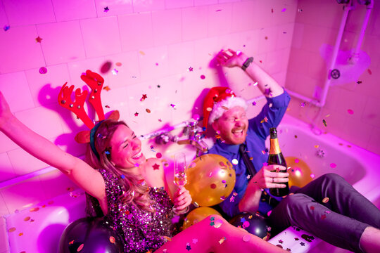 Couple having fun at New Year party midnight countdown drinking champagne