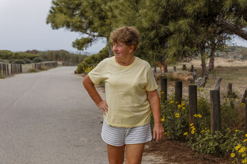 Stylish elderly woman walking in the park, the concept of a healthy lifestyle