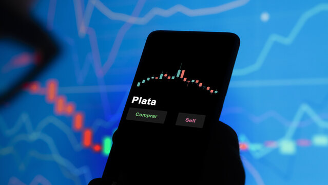 Un inversor est&aacute; analizando el plata etf fondo en pantalla. Un tel&eacute;fono muestra los precios del ETF para invertir. Texto en espa&ntilde;ol.