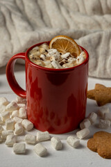 Hot chocolate or cocoa with marshmallows in red cup with cookies. Christmas drink.