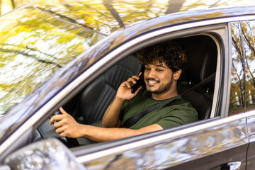 transport, communication and people concept. Indian man or driver driving car and calling on smartphone