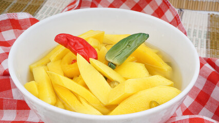 Top View Homemade Manisan or Asinan Mangga is Candied Young Mango Pickles, served on white bowl, Indonesia Traditional Food