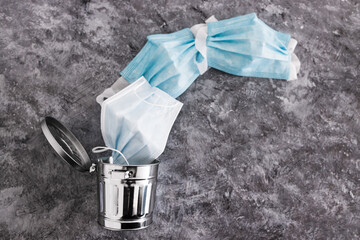 covid pandemic ending or littering issues, disposable surgical masks flying into or out of garbage...