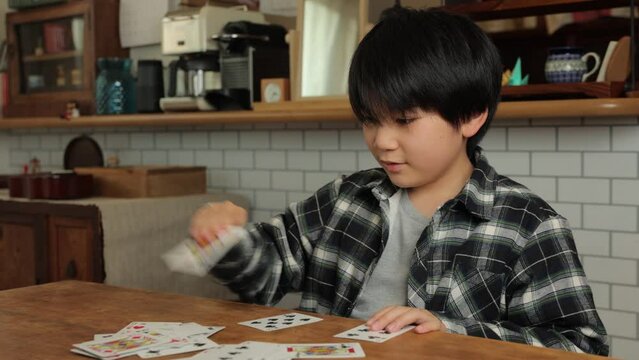 Asian teen boy playing cards at home. Speed Card.	