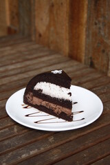 Chocolate cake slice for dessert on a wooden slatted table
