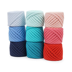 Spools of multi-colored cotton threads on a white background. Cotton yarn in ball and bobbins
