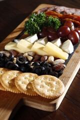 charcuterie board with crackers, olives, nuts, cheeses, grapes, pepperoni and salami