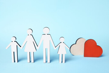 Figures of family stainding near heart on light blue background. Insurance concept