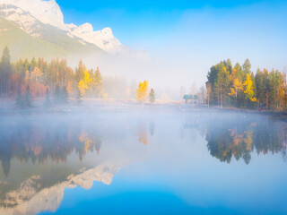 Fall. Landscape during sunrise. Autumn trees on the river bank. Mountains and forest. Reflections on the surface of the lake. Vivid colours during dawn. Banff National Park, Alberta, Canada.