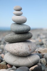Naklejka na ściany i meble Stack of stones on beach against blurred background, closeup