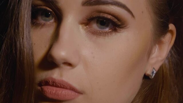 Close up shot of a beautiful women looking into the camera seductively with long eyelashes, hazel eyes, and looking seductive and flirty