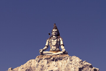 Fototapeta premium Indian god Shiva meditates on the top of a mountain.