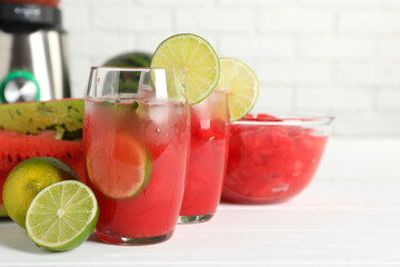 Fresh watermelon drink with lime and ingredients on white wooden table