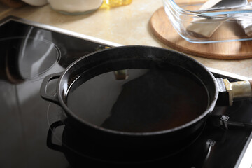 Frying pan with used cooking oil on stove, closeup