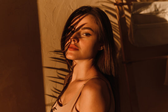 Stylish Photo Of A Female Model In The Shade Of A Palm Leaf.