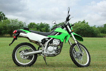 Fototapeta na wymiar Stylish cross motorcycle on green grass outdoors
