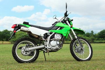 Fototapeta na wymiar Stylish cross motorcycle on green grass outdoors