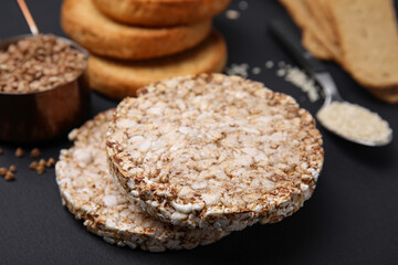 Rice cakes and rusks on black table, closeup