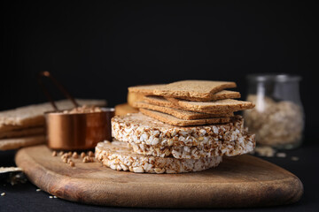 Rye crispbreads, rice cakes and rusks on black table