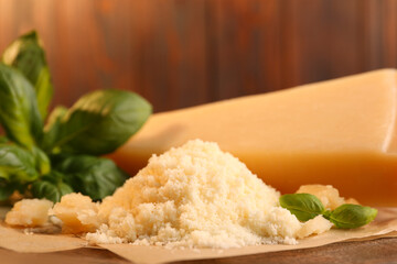 Delicious grated parmesan cheese and basil on parchment paper, closeup