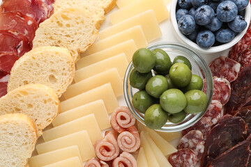 Tasty parmesan cheese and other different appetizers as background, top view