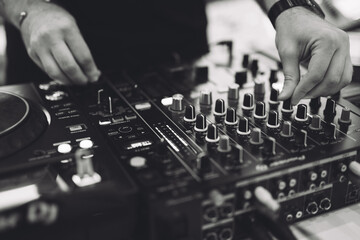 a DJ plays music on a controller at a party.