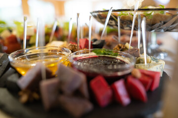 a dish of various delicious cheeses and a plate of honey.
